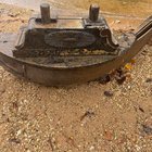 ​Large, heavy cast iron and wooden thing that washed up on the shore of a river.