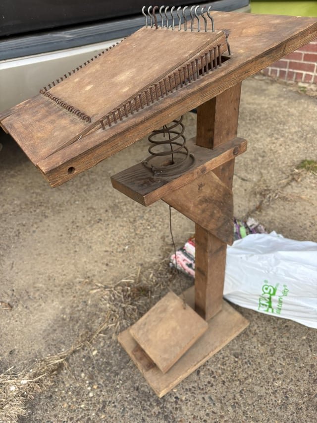 ​Wooden pedestal with spring activated board. Spring controlled by foot. Nails and hooks along top and sides.