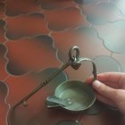 ​A cup and an articulated hook, maybe brass, kinda heavyweight. I first thought it was however used for candles, but I can’t see any trace of wax.
