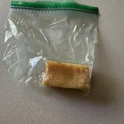 ​Small, tan, rectangular (plastic?) block in our fully fenced backyard. Slightly concave on 2 of the long sides. Looks like soap or processed beeswax but is much harder.