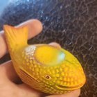 ​Small yellow ceramic object that I believe is in the shape of a whale. It’s mostly hollow, about 4-5 inches long, weighs a few ounces, and is covered in dimples like a golfball.