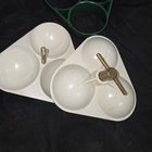 Green and white plastic thing that has brass hardware to hold 3 separate pieces together making 3 hollow spheres in a triangular configuration
