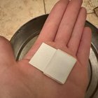 Plastic wrapped white object found in can of buttons