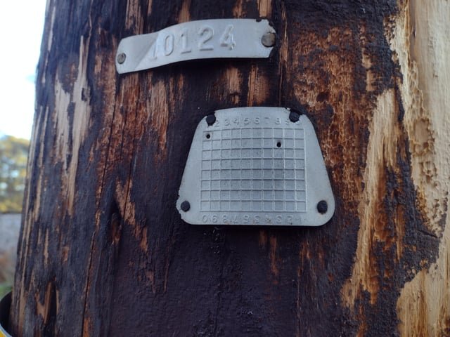 Numbered Metal Punchcard attached to Power Poles with Two Holes Punched