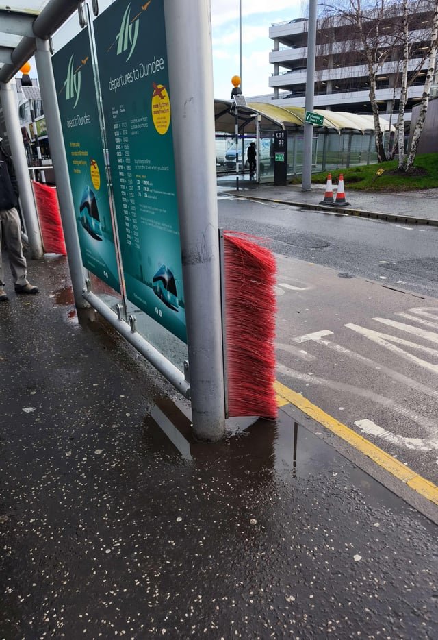​Red brushes at airport bus stop