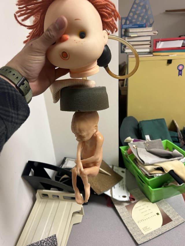This doll head with a fetus attached at the bottom and pump at back..found in a school