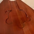 4’ teardrop-shaped wood coffee table with carved circular inset (~15” x 9”) and drawer. Purpose of the carved section?