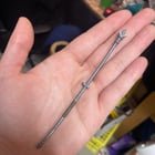 Metallic and brown thin plastic beams with doohickey on one end