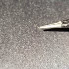 Very small, thin, slivers of gold colored metal I keep finding stuck in our clothes