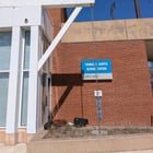 What is this roughly ~20 foot chain hanging from a steel beam with rocks at the bottom at a train station/bus stop?