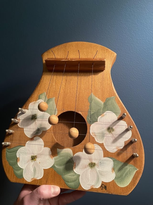 ​4 string, 4 ball instrument- all made of wood except for the strings