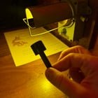 2 inch long plastic mallet (?), attached to a metal light fixture by a small chain.