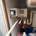​Under a kitchen sink. 3 plastic rods that pull out with metal cores. Main element seems to have a motor inside and everything is controlled by 30 minute timer