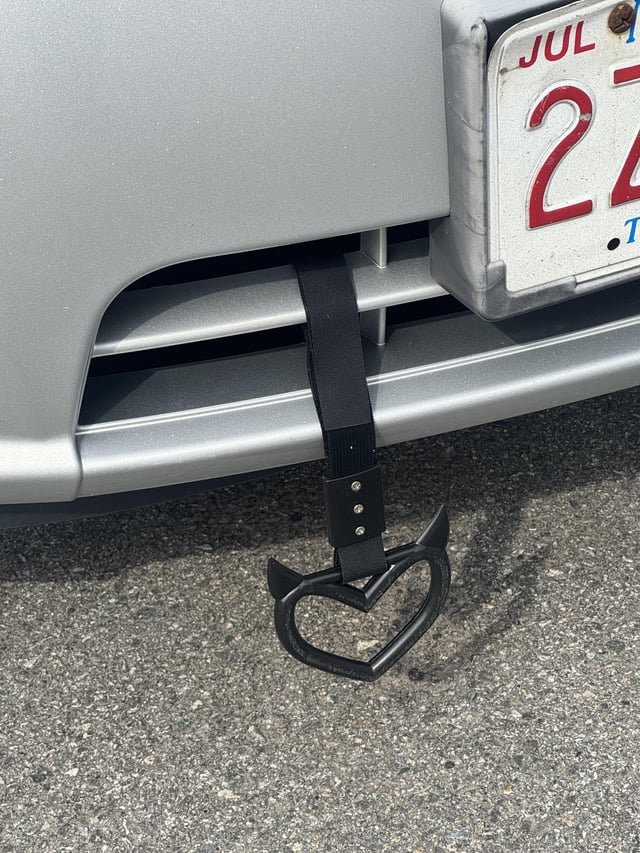 A metal pointy thing dangling from the front of the car