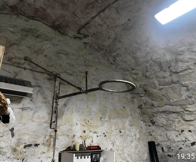 ​Metal loop protruding from wall of medieval tower basement