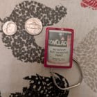 ​Small object with a removable wire piece, an image of a paint can and a woman