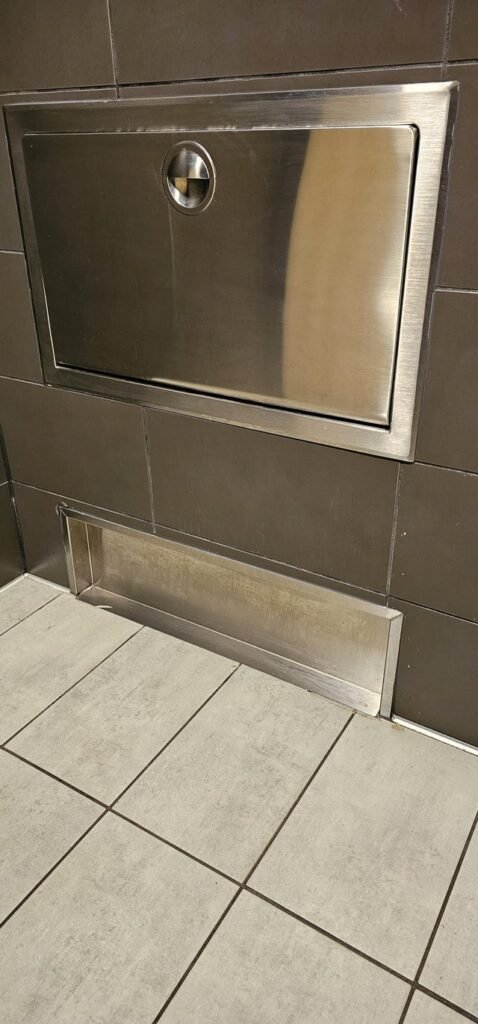 Stainless steel shallow cutout in wall of McDonald’s restroom.