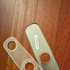 Oblong metal piece with 1 hole and plastic piece that attached to it with three holes