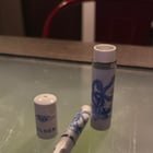 Small white cigarette/joint holder? One hitter? with blue dragon design and letters “NZH”.