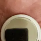 ​Small shiny round electronic device with one button that beeps when pressed