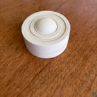 ​Small off white cylindrical item with rounded button and AAA batteries.